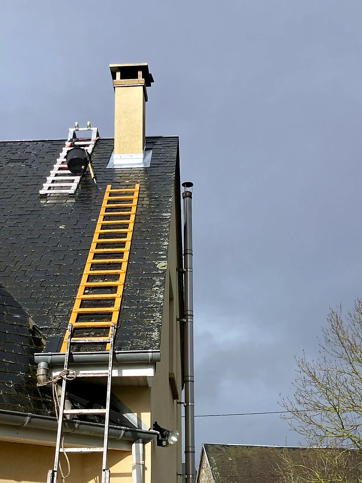Intervention de zinguerie autour d'une cheminée sur toiture ardoise